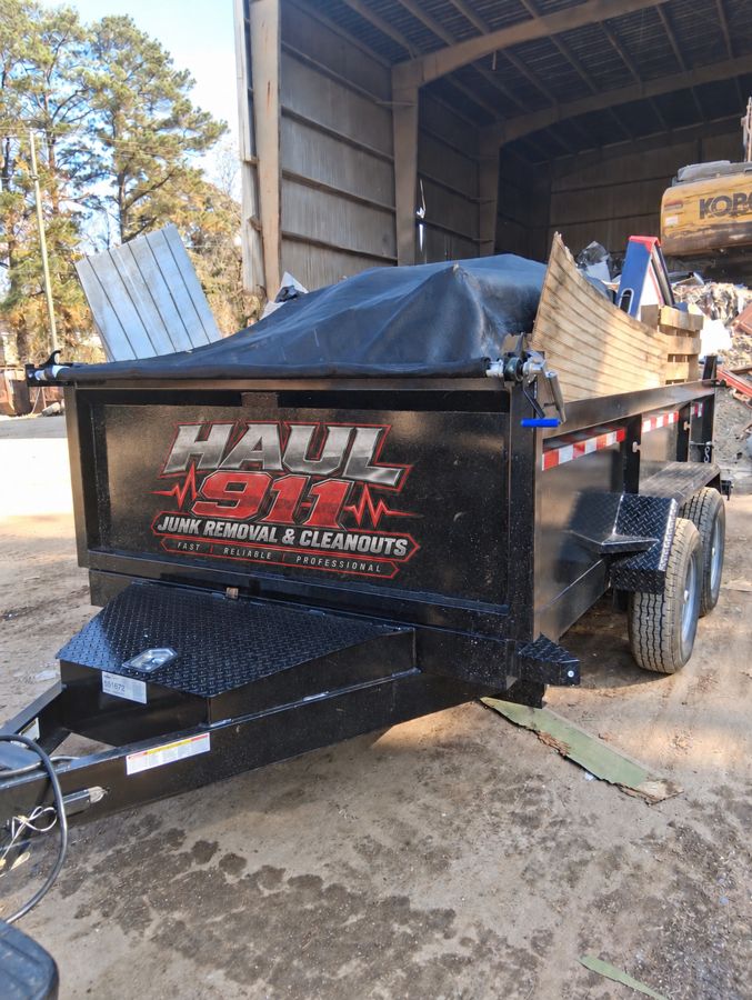 Haul 911 branded dump trailer unloading at the scrap yard